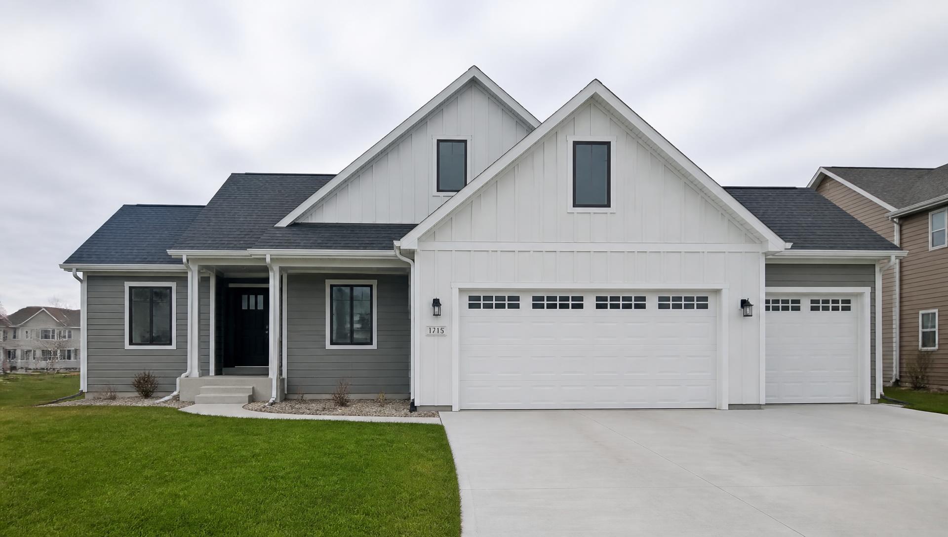 Central Iowa home with new white board-and-batten and gray lap siding under natural daylight